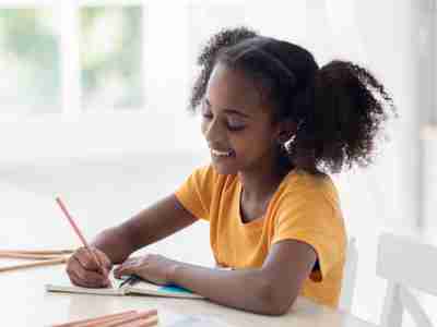 Teenage girl taking notes and doing homework.