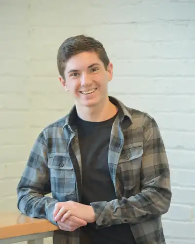 Headshot of Zach Betz, a caucasian teenage boy with brown hair wearing a plaid flannel.