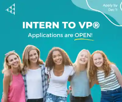 Girls smiling in front of the Intern to VP logo